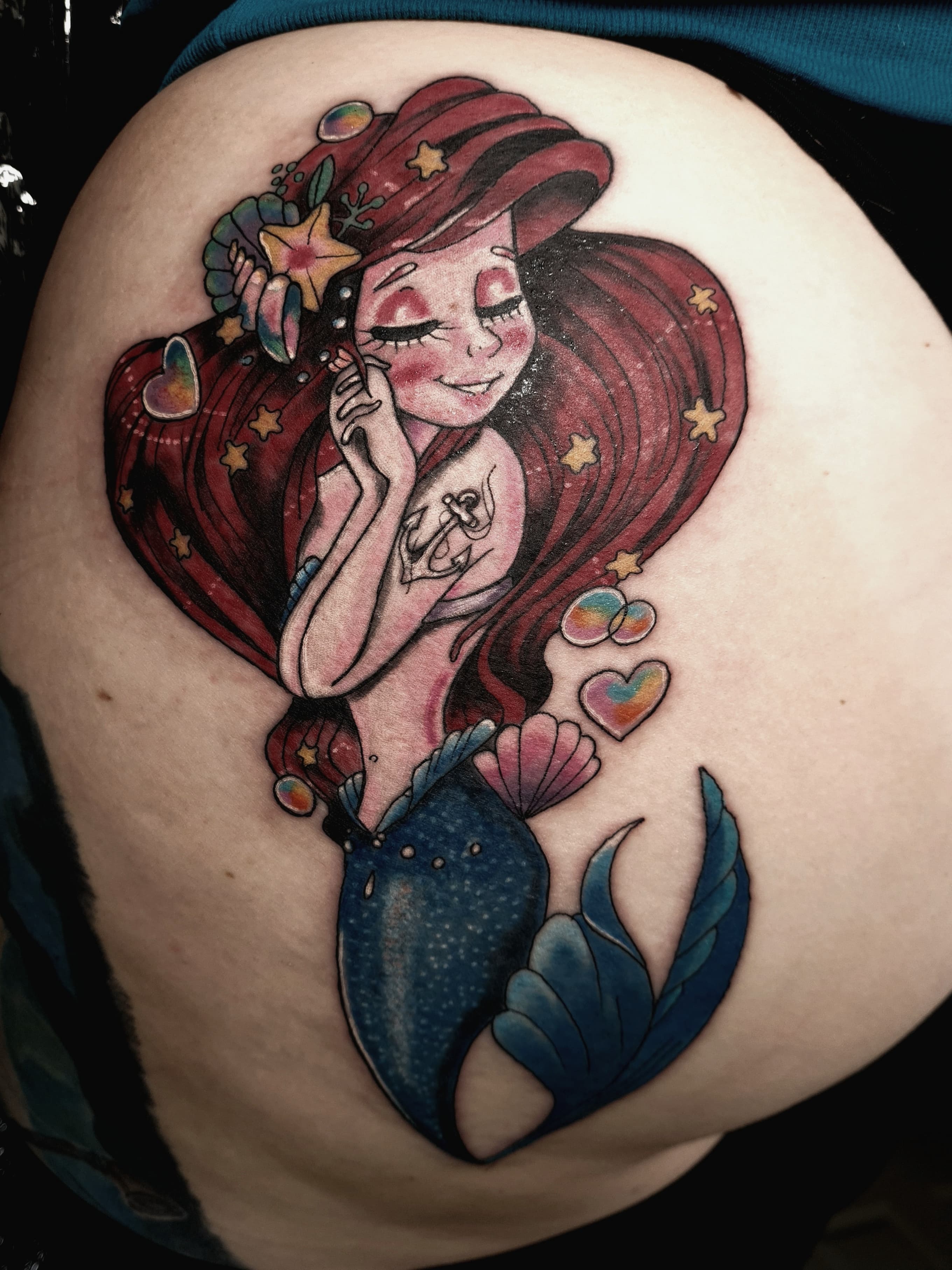 Kolorowy tatuaz syrenki Arielki z bajki Disneya na udzie w stylu cartoon
