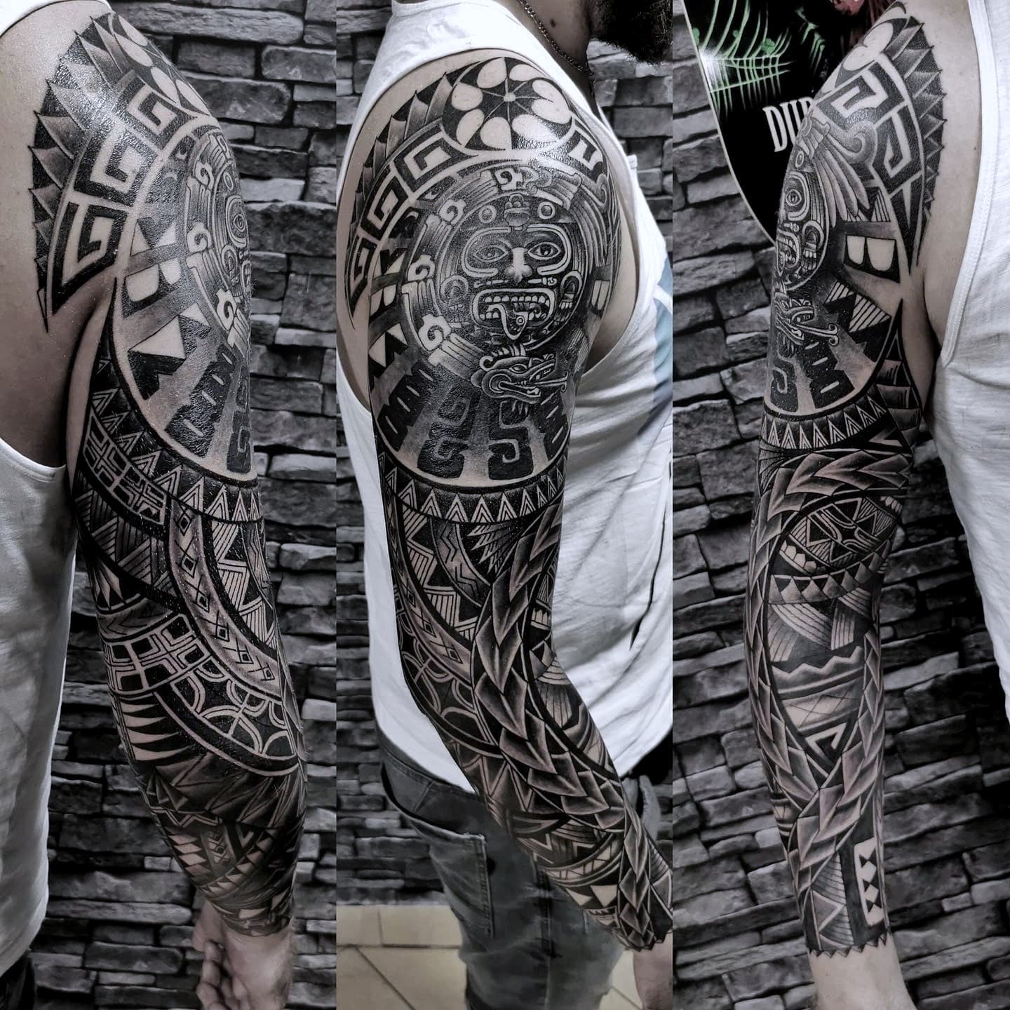 Pelny sleeve z azteckimi i polinezyjskimi wzorami plemienny tatuaz na calym ramieniu