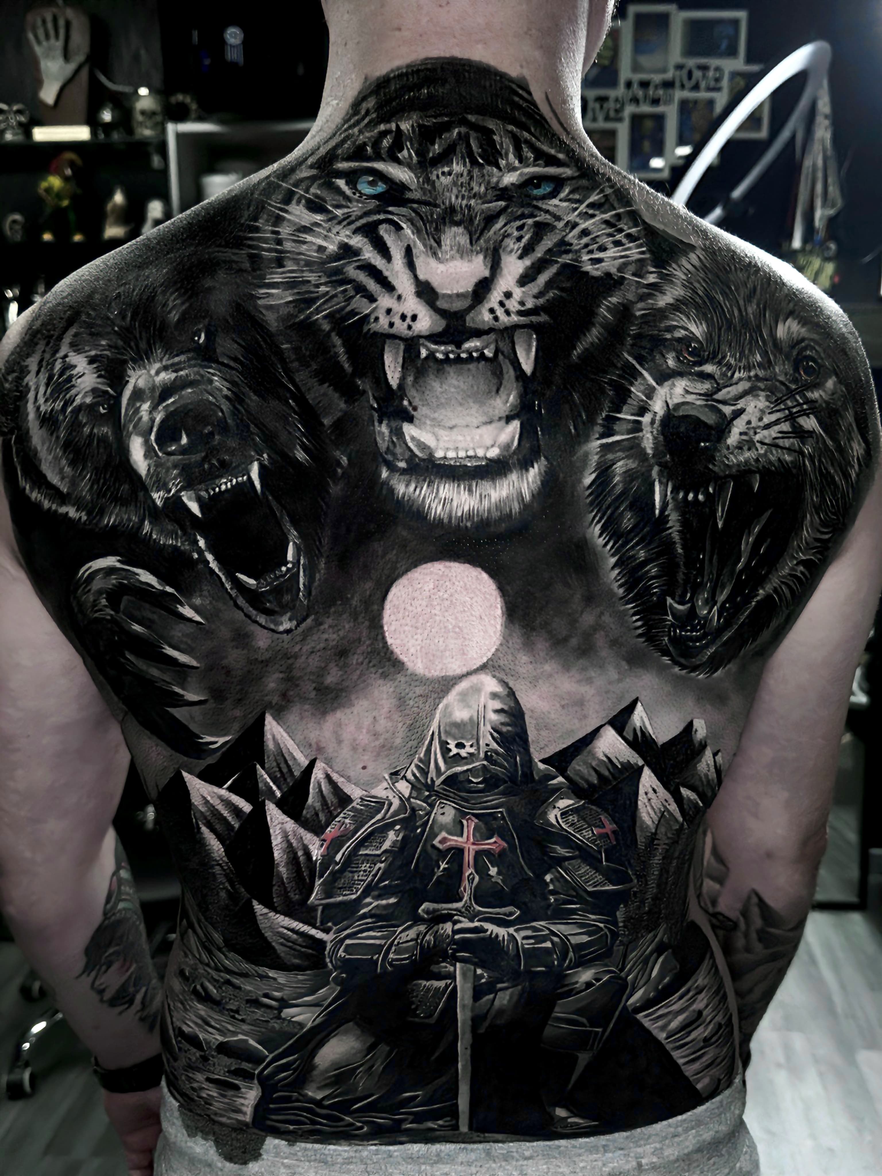 Realistyczny tatuaz na calych plecach z tygrysem niedzwiedziami wilkiem i rycerzem krzyzowcem