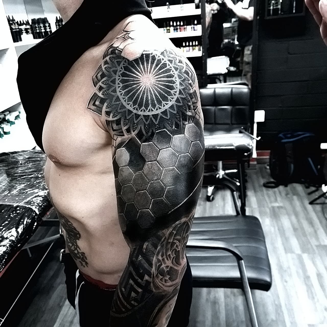 Czarno-bialy rękaw tatuazu z mandalą, heksagonami i geometrycznymi wzorami na całym ramieniu