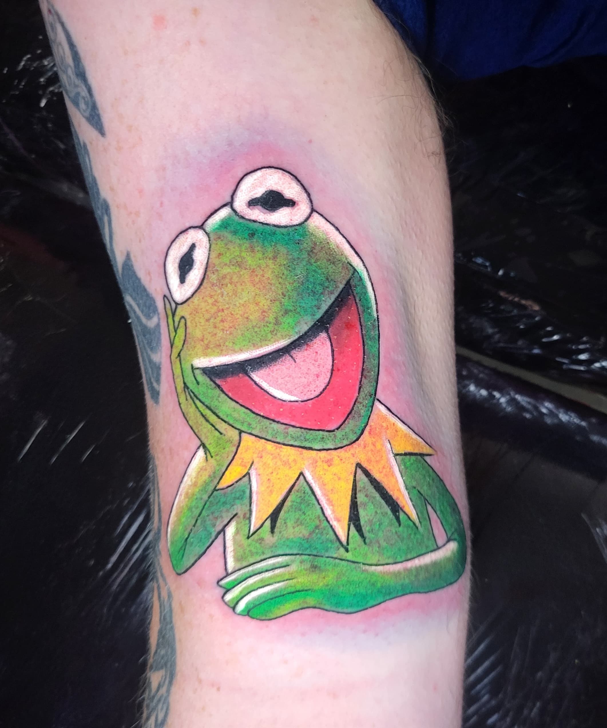 Kolorowy tatuaz żaby Kermita z Muppetów na przedramieniu w stylu cartoon