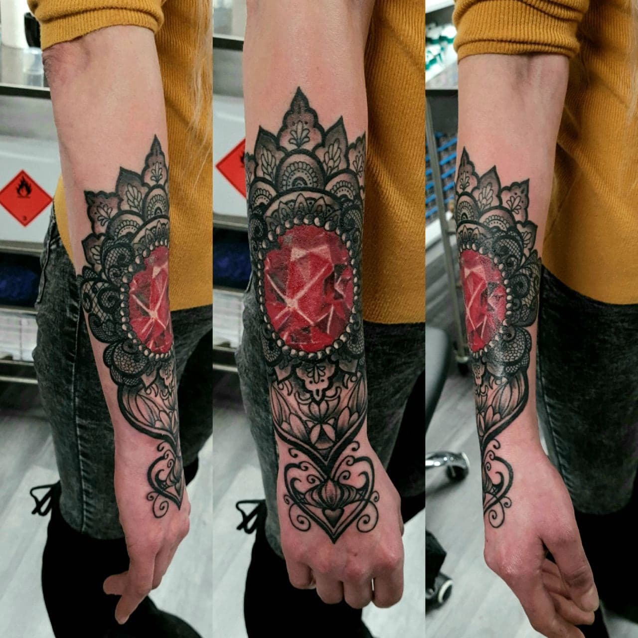 Ornamentalny tatuaz z czerwonym kamieniem szlachetnym i mandala na przedramieniu kobiety