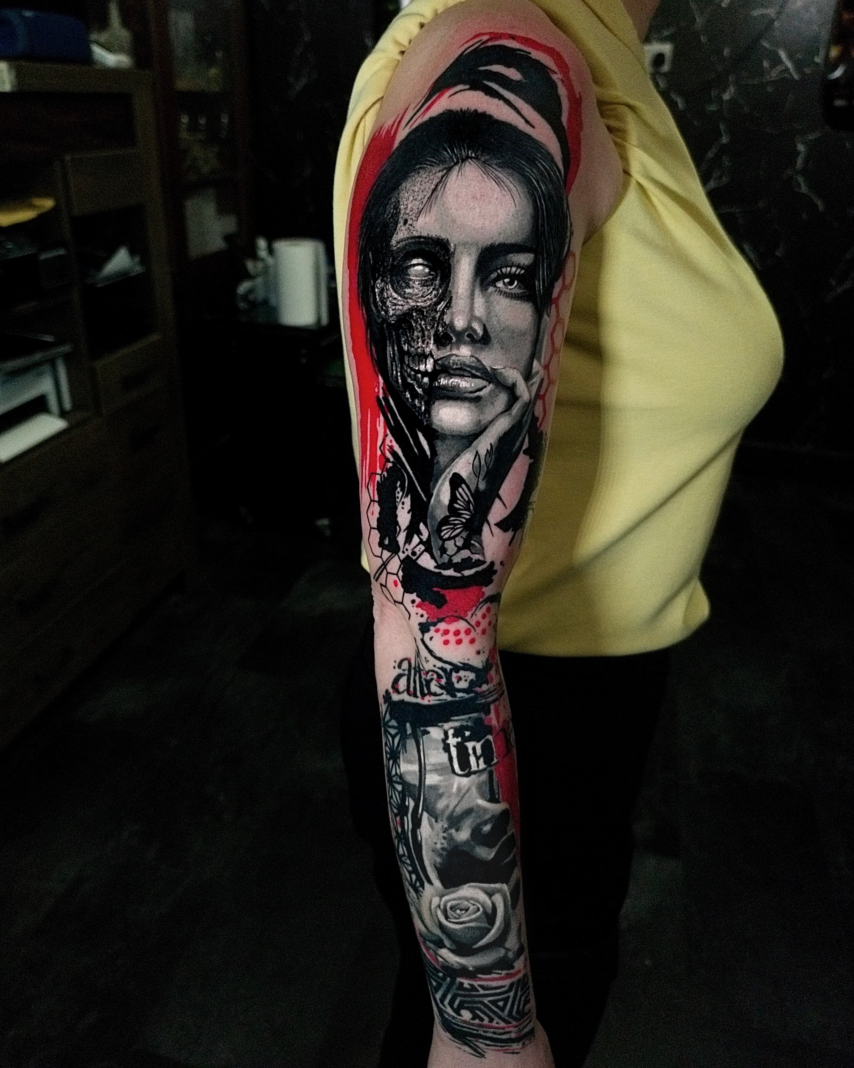 Realistyczny tatuaz kobiety z pół czaszka motylami i roza na calym rekawie z czerwonymi akcentami