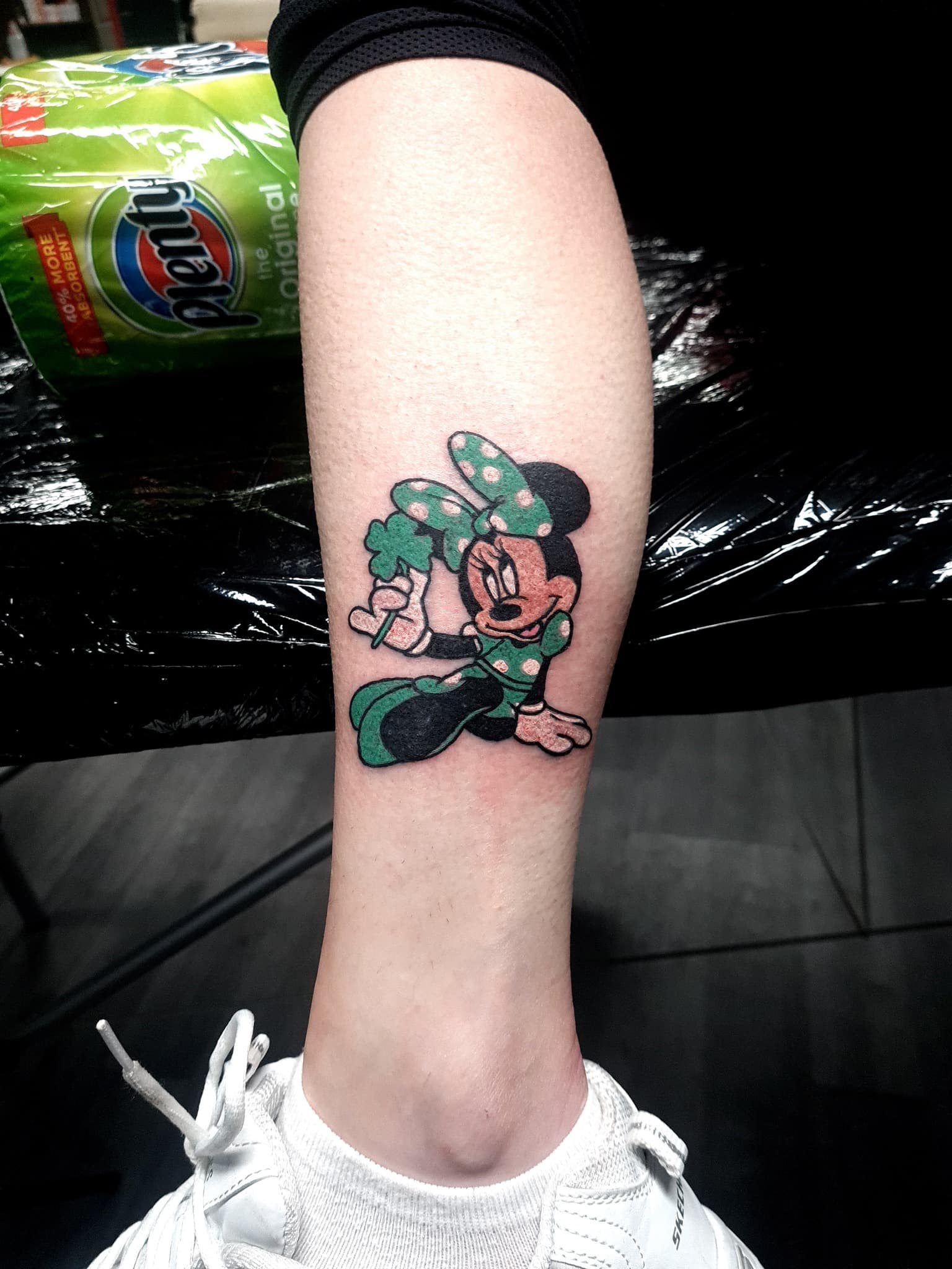 Kolorowy tatuaz postaci Minnie Mouse z koniczyna na lydce w stylu cartoon