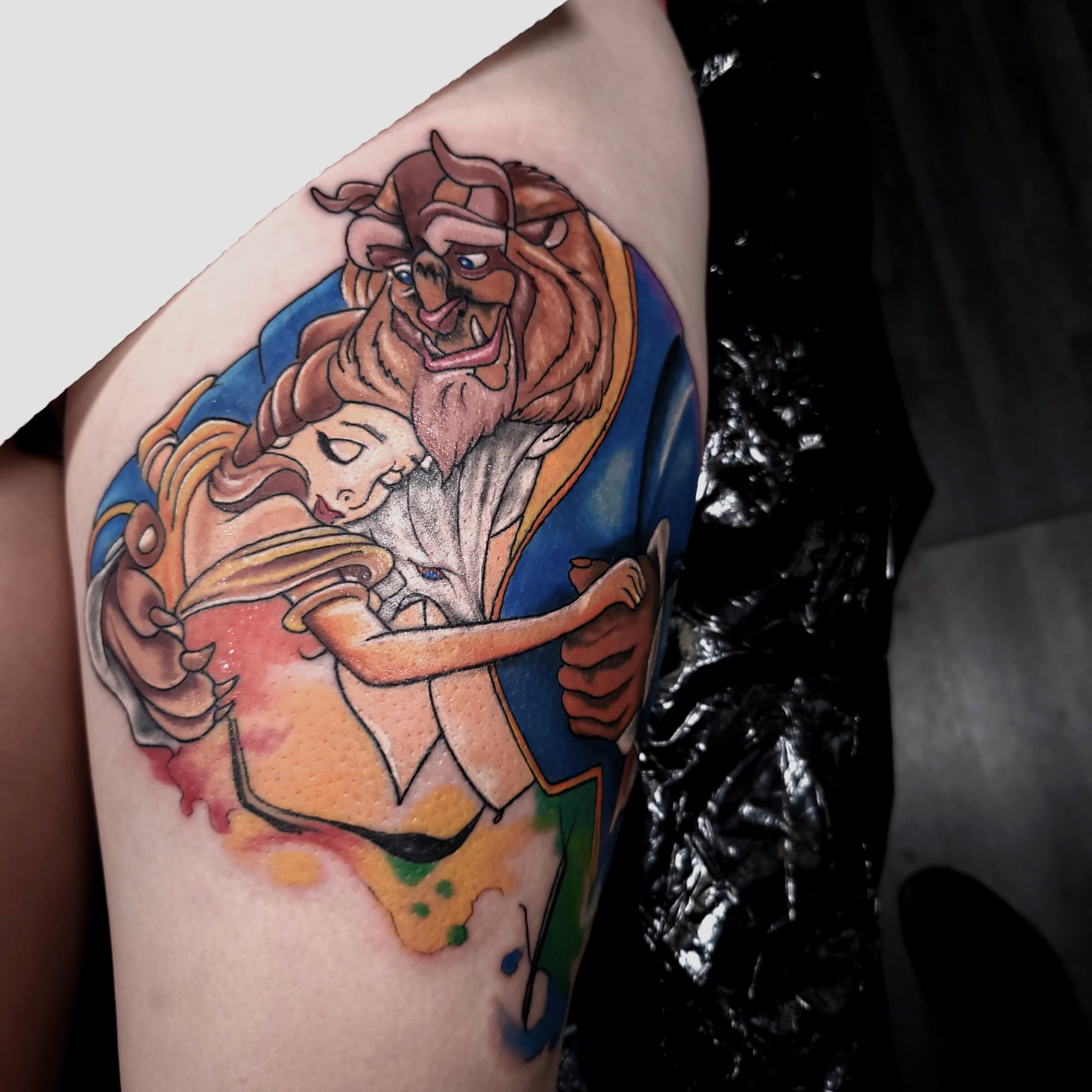 Kolorowy tatuaz Pieknej i Bestii z animacji Disneya tanczacych razem na udzie