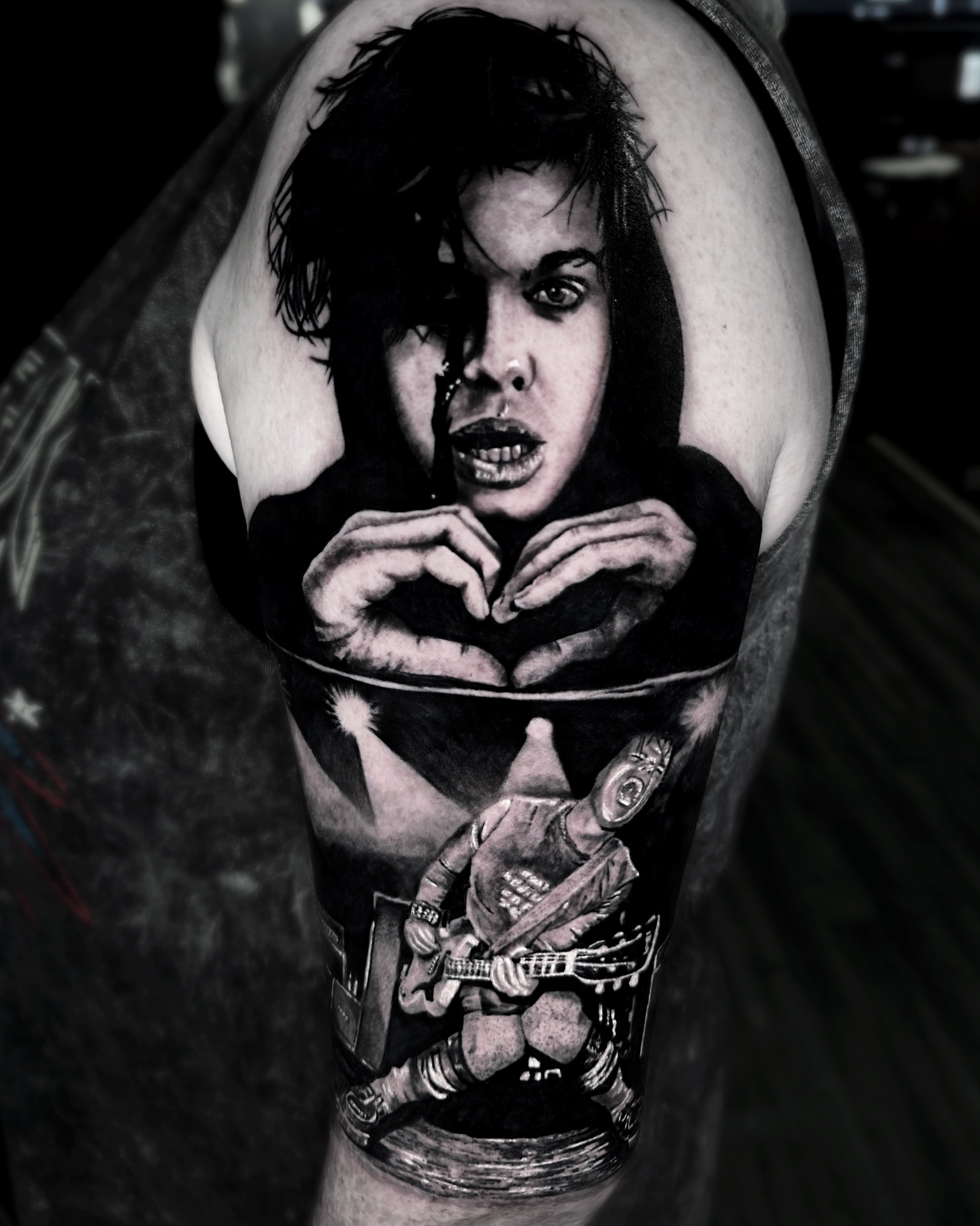 Realistyczny tatuaz portret muzyka rockowego z gitara na ramieniu w odcieniach szarosci
