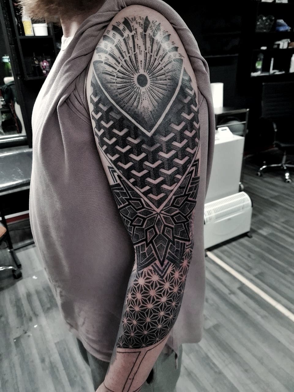 Geometryczny czarno-szary sleeve z mandala i wzorami sacred geometry na calym ramieniu
