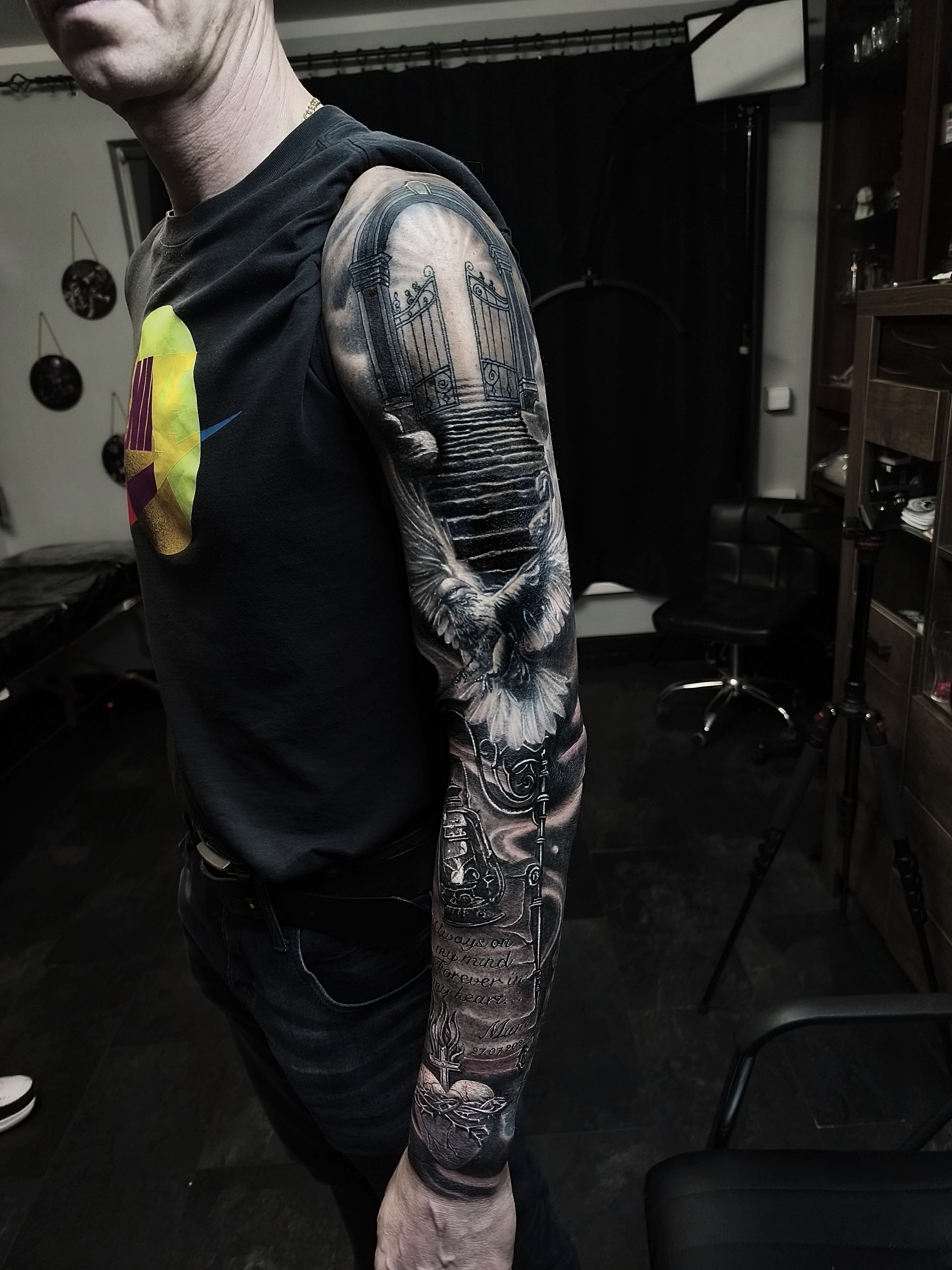 Czarno-szary rękaw tatuazu ze schodami do nieba, orłem w locie i bramą niebios